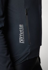 Black cycling jacket with a structured fit, featuring a zippered pocket and reflective branding. Made from a weather-resistant material.