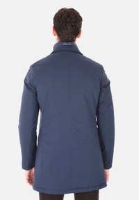 Cappotto blu navy a maniche lunghe con vestibilit sagomata, texture liscia e colletto alto. Presenta dettagli delle cuciture e orlo dritto.