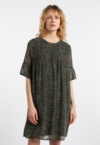 Kukkaistennyt tummanvihreä mekko, jossa on lyhyet, liehuvat hihat. Mekossa on väljä malli, pyöreä pääntie ja pienen värikkäiden kukkien kuvio.