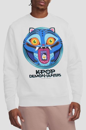 Mann trägt weißen Pullover mit blauer Cartoon-Tiger-Gesicht, das Fangzähne und Zunge zeigt und eine Notiz mit der Aufschrift "Rette die Taube" trägt, darunter der Text "KPOP DEMON HUNTERS".