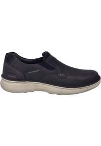 Zapato de piel azul oscuro tipo slip-on con paneles laterales elásticos, costuras blancas y una suela de goma texturizada de color claro. Presenta un branding mínimo.