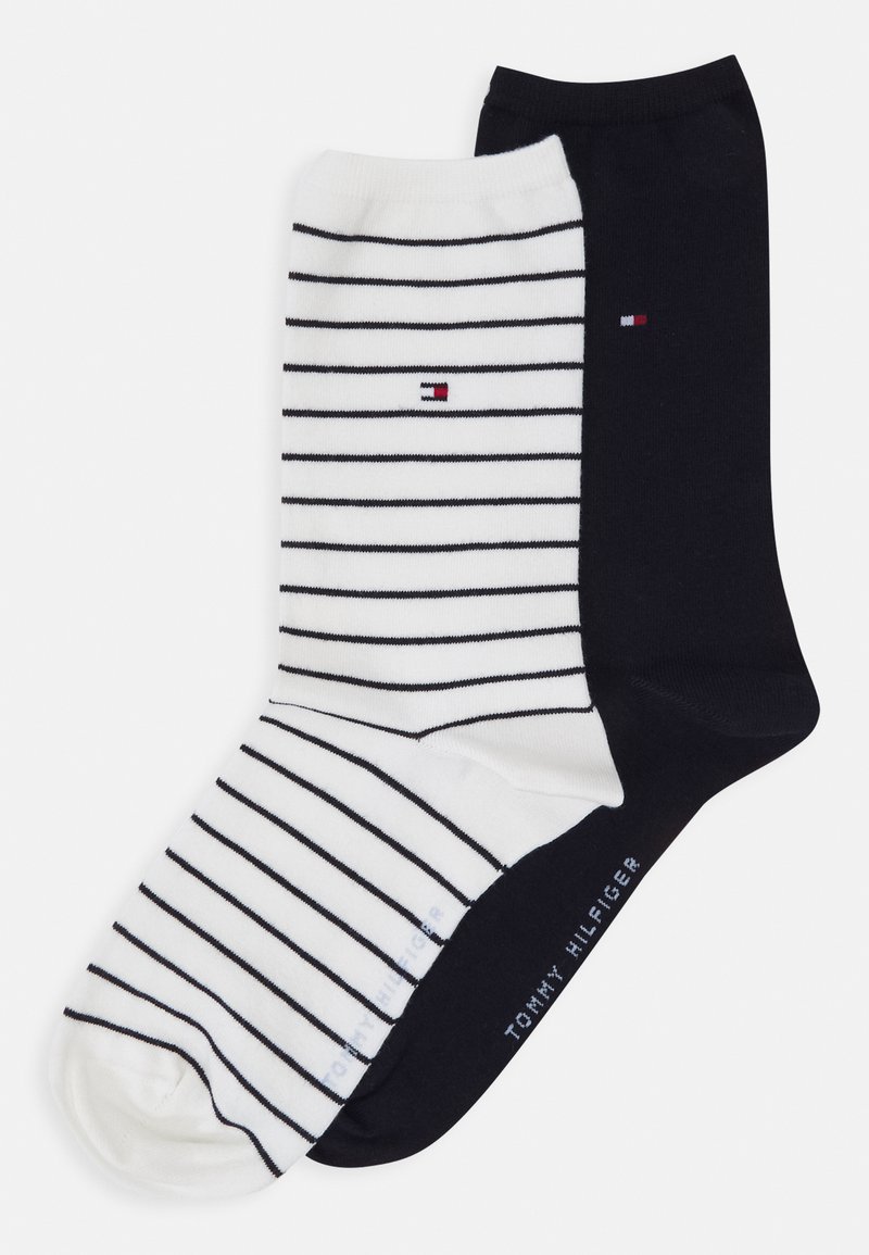 Pair of socks: one white with navy stripes and logo, one solid navy. Cotton blend, crew length, with a smooth texture and ribbed cuffs.