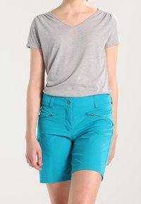 Šedý krátký rukáv V-krku top v kombinaci s tyrkysovými kraťasy ke kolenům, které mají přední knoflík, zipové kapsy a hladkou strukturu látky.
