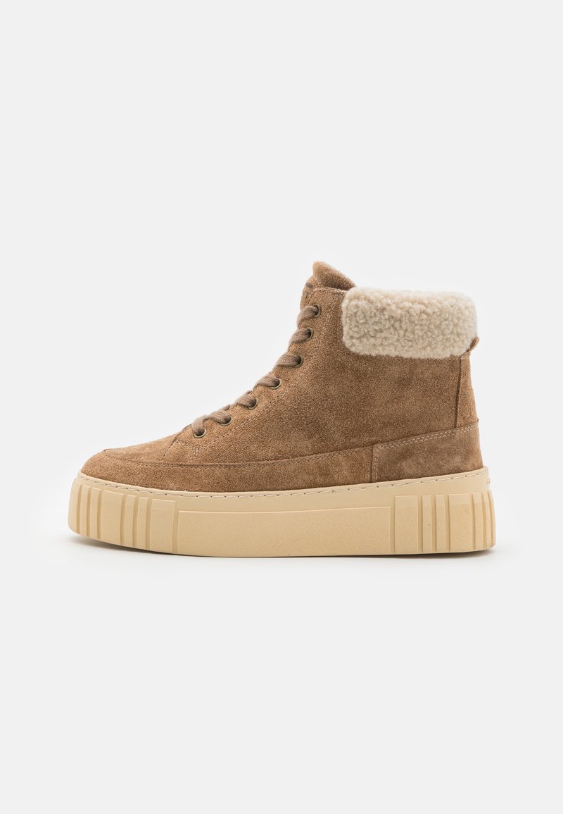 Brune suede høyhælte sneakers med en fluffete beigefarge krage, tykk kremfarget plattformsåle og snøresystem. Strukturerte overflater og sømdetaljer.