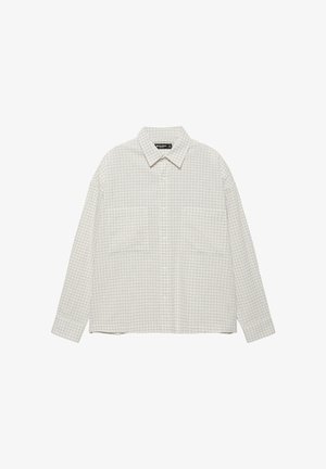 Hosszú ujjú, bézs-fehér kockás, gombos ing gallérral és két elülső mellzsebbel, fehér háttéren laposan elhelyezve.