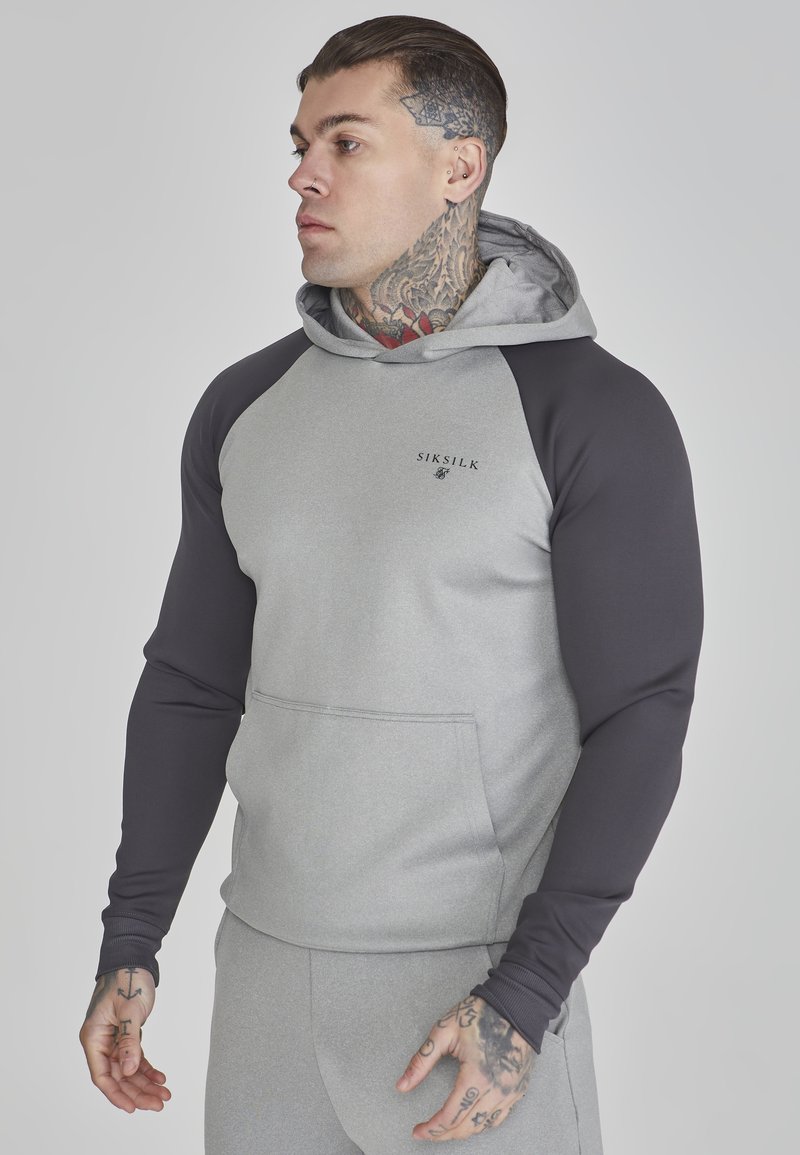 Felpa grigia e grigio scuro con tasca a marsupio, caratterizzata da un design a contrasto e polsini a costine; logo Siksilk sul petto.