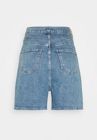 Jeansshorts i ljusblått. Har hög midja, fem fickor och en rå nederkant. Tyget har en subtil struktur med ett slitigt utseende.