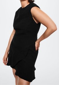 Schwarzes Kleid mit tailliertem Oberteil und kurzen Ärmeln, ausgestattet mit einem strukturierten Stoff, asymmetrischem Volant-Saum und einer glatten Silhouette.