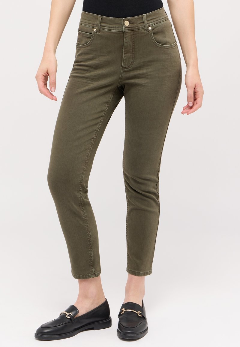 Olive green slim-fit pants with a mid-rise waist, five pockets, and subtle stitching details. Material appears smooth and slightly stretchy.