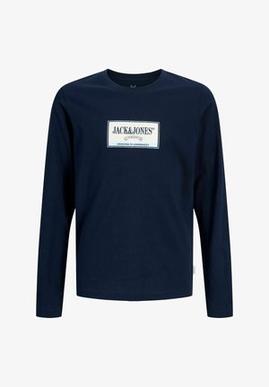 Granatowa koszula z długim rękawem, zaokrąglonym dekoltem i białą prostokątną naszywką z logo z napisem "Jack & Jones Designed in Copenhagen" na piersi.