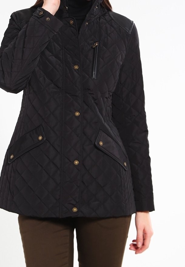 Veste matelassée noire avec un col haut, dotée d'une poche zippée et de deux poches à rabat à l'avant. Boutons marron et accents en cuir aux épaules.