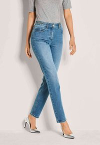 Lichtblauwe denimjeans met een rechte pasvorm, voorzien van voorzakken, een medium hoge taille en subtiele hardwareaccenten. Draag met zilveren hoge hakken.