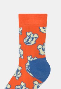 Oranžové ponožky s modrým opatkem, které mají opakovaný vzor světlomodré zvířecí tváře. Jsou vyrobeny z měkké pletené tkaniny s žebrovaným lemem.