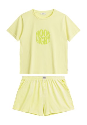 Żółty zestaw odzieży loungewear z bawełny, składający się z koszuli z nadrukiem "MOON LIGHT" oraz pasujących szortów z elastyczną talią i detalami w postaci guzików.