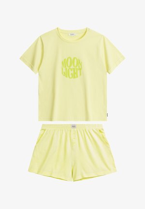 Żółty zestaw odzieży loungewear z bawełny, składający się z koszuli z nadrukiem "MOON LIGHT" oraz pasujących szortów z elastyczną talią i detalami w postaci guzików.