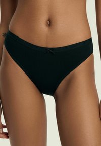 Czarny bawełniany bikini o gładkiej fakturze, z niskim stanem i małą satynową kokardką na środku przodu.