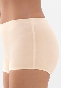 Beige puuvillaiset hipster-alushousut, jotka ovat saumattomat ja sileäpintaiset, keski-nostolla ja ilman näkyviä saumoja.