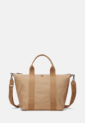 Beige Tragetasche aus strapazierfähigem Stoff, mit zwei oberen Griffen, einem abnehmbaren Schultergurt und minimalistischem Design mit Logodetail.
