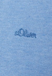 Jasnoniebieska dzianina o gładkiej fakturze z wyszywaną nazwą marki "s.Oliver" w ciemniejszym niebieskim kolorze w prawym dolnym rogu.