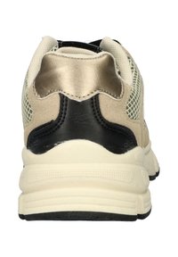 Beige sneaker met een gestructureerde mesh bovenkant, zwarte hielkap en crèmekleurige tussenzool. Beschikt over een gewatteerde kraag voor comfort.