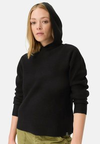 Zwarte hooded sweater met ribbelstructuur, aangesloten mouwen en een relaxte pasvorm. De stof lijkt zacht en warm, met een subtiel ontwerpelement aan de onderrand.