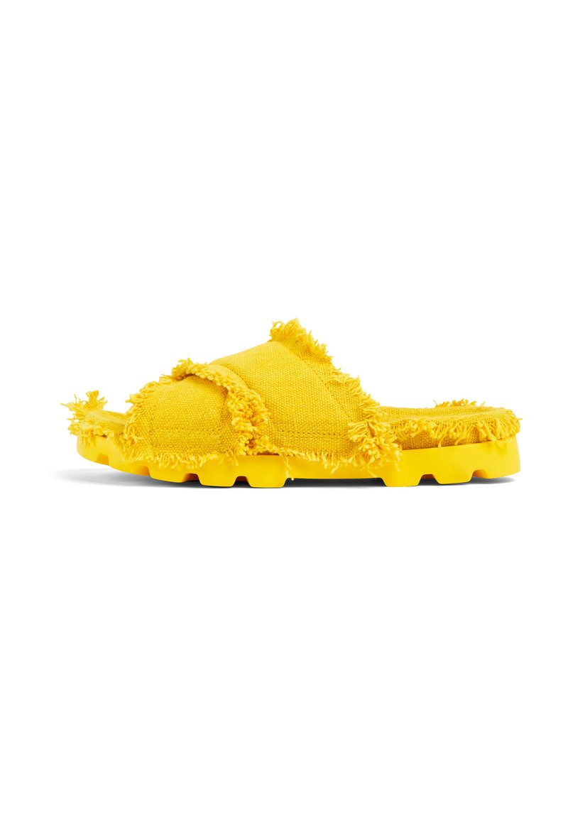 Gula slip-on sandaler med fransad tygdetalj och texturerad gummisula. Har en bred, öppen tådesign och en dämpad fotbädd.