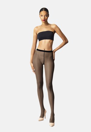 Braun gemusterte Strumpfhosen mit feinem Pünktchendesign, kombiniert mit einem schwarzen Bandeau-Top. Das Model trägt beigefarbene High Heels.