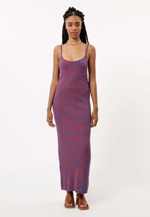 Robe maxi tricotée avec des bretelles spaghetti, présentant un motif à rayures verticales rouges et bleues. Texture lisse, silhouette ajustée.