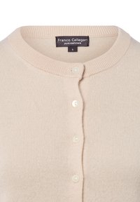 Kardigan z kaszmiru w kolorze kremowym, z okrągłym dekoltem, czterema kremowymi guzikami i metką "Franco Callegari pure cashmere" w rozmiarze małym.