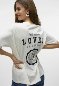 Biała bawełniana koszulka o luźnym kroju, z czarnym napisem "LOVE" oraz grafiką na plecach, krótki rękaw i boczne rozcięcia.