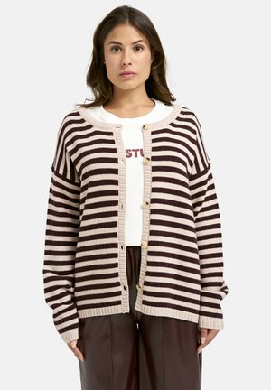 Striped cardigan in beige and dark brown, featuring a button-up front, loose sleeves, and a ribbed hem. Worn over a white shirt.