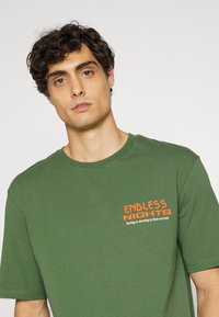 Endless Nights UNIFORM ESSENTIALS NIGHTS LOGO UNISEX - T-shirt estampada - forest green