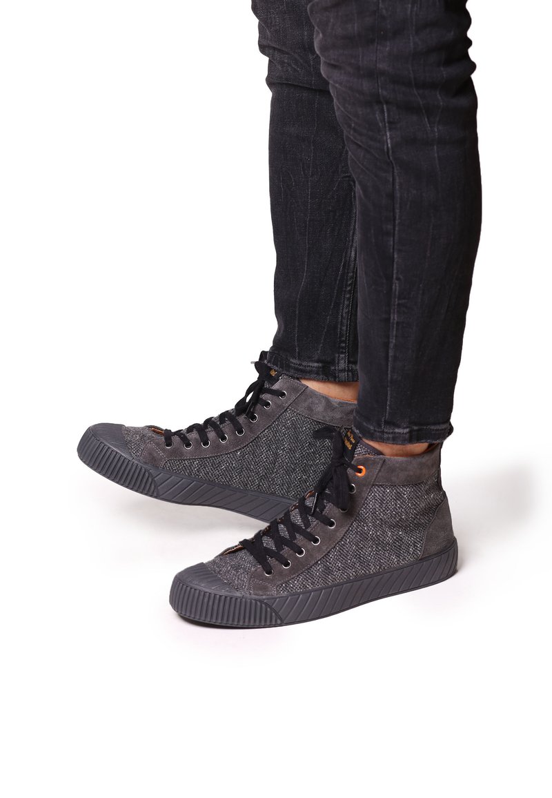 Höga sneakers gjorda av grått tyg och mocka, med en strukturerad yta, svarta snörningar och en gummisula med upphöjda detaljer.