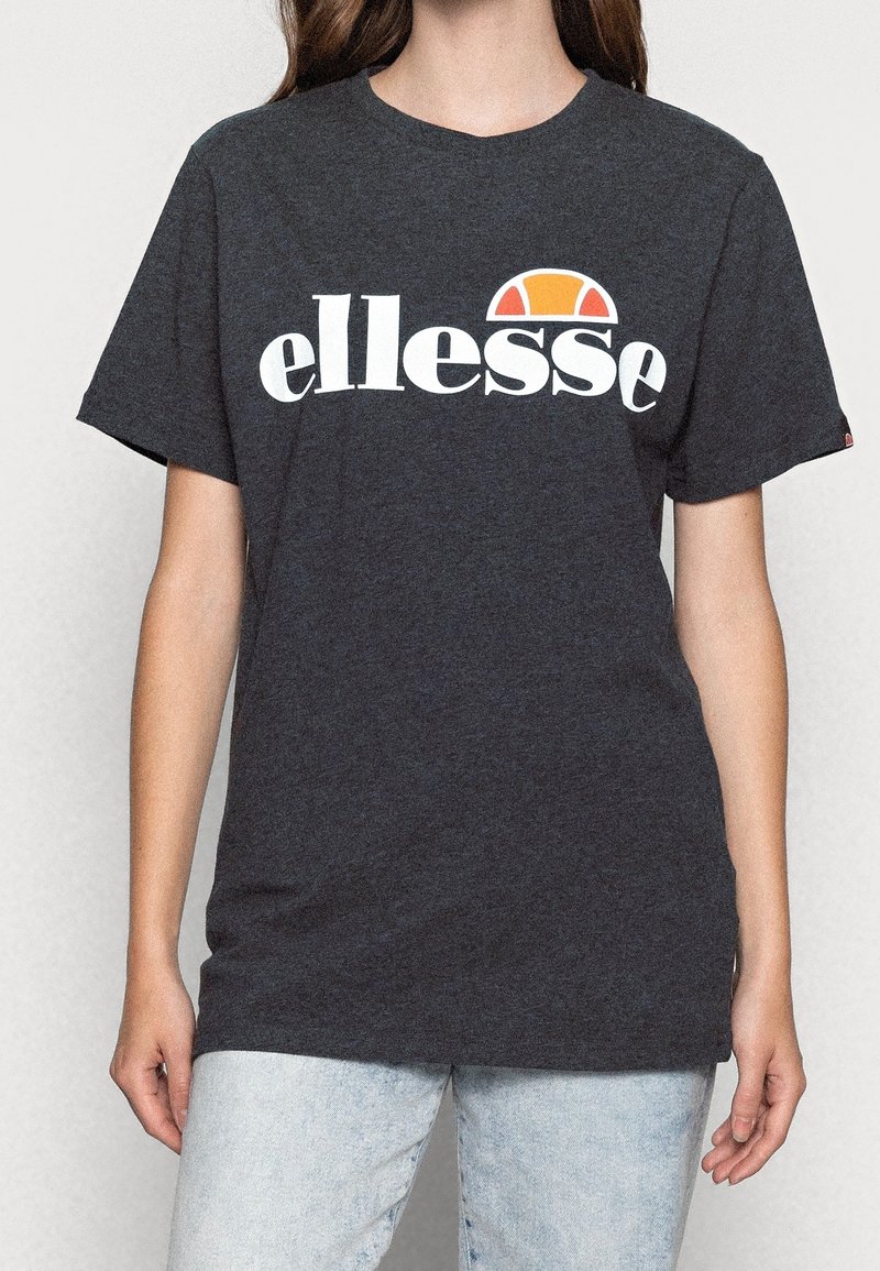 Dark gray cotton t-shirt featuring a white "ellesse" logo and a distinctive orange and red semi-circle graphic above the text. Short sleeves.