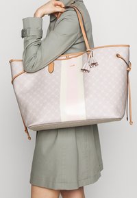 Grote tote bag in lichtroze textuurmateriaal met een crèmekleurige streep. Voorzien van tan lederen accenten en decoratieve franjes.