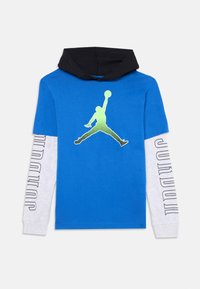 T-shirt azul de manga curta com capuz preto. Apresenta uma silhueta verde de uma figura a saltar, com mangas longas cinzentas exibindo "JORDAN."