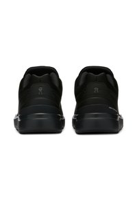 Mustat urheilukengät, joissa on teksturoitu verkkouppoasuminen, pehmustettu kaulus ja tasainen kumipohja. Varustettu kohokuvioiduilla logotiedoilla kantapäässä.