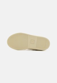 Sole di scarpa in gomma beige con scanalature orizzontali e verticali. Presenta un logo e un testo che recita "Gomma Amazzonica." Superficie liscia e texture.