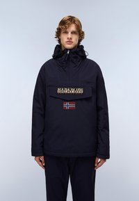 Marineblå genserjakke med høy krage, frontlomme og brodert norsk flaggdetalj; laget av værbestandig stoff.