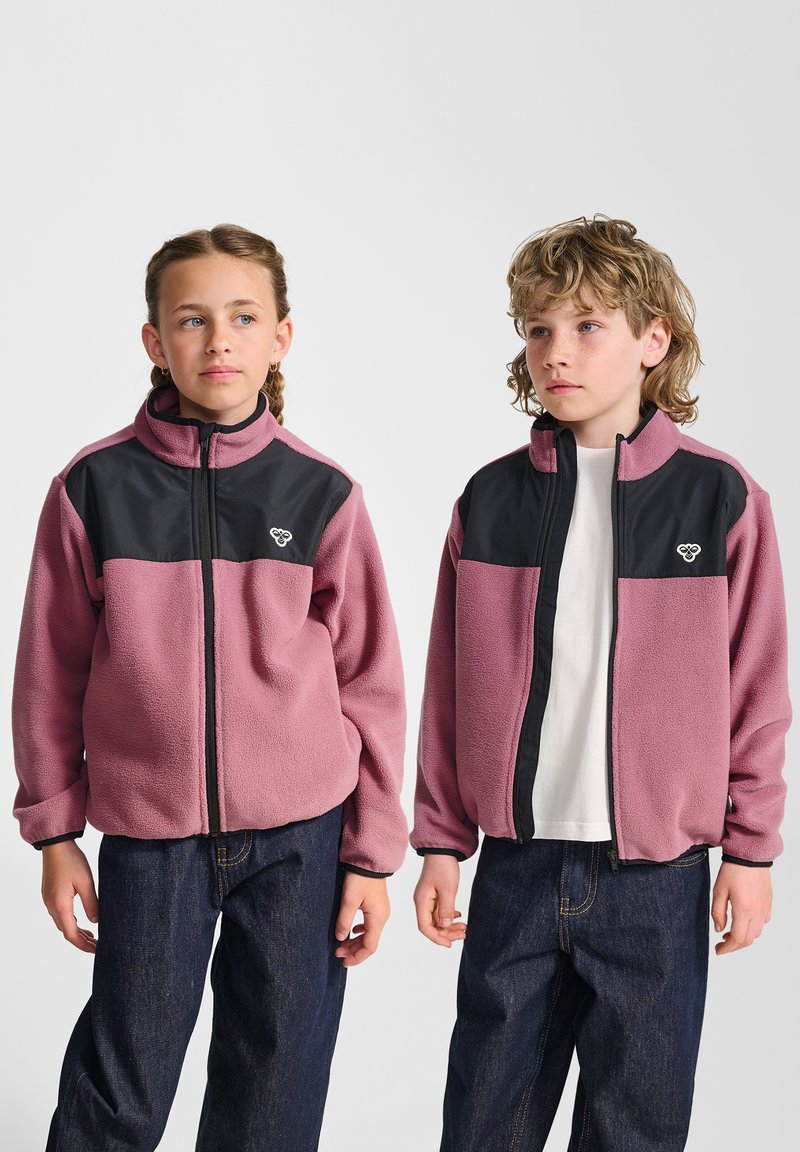 Fleecejack in lichtroze en zwart, met rits en hoge kraag. Heeft lange mouwen en een geborduurd logo op de borst.