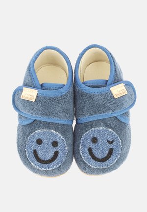Pantofole in tessuto blu con design di faccine sorridenti, caratterizzate da un esterno in tessuto morbido, una strap in Velcro e una suola leggera.