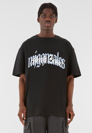 Svart bomull t-skjorte med oversized passform, med hvit og lyseblå tekst "Eternally Blessed" i stilisert skrift over forsiden.