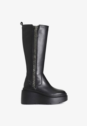 Black leather knee-high boots with a chunky platform sole, featuring a decorative zipper on the side and smooth texture.