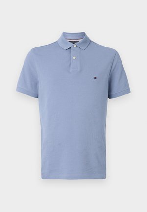 Polo majica v svetlo modri barvi, kratki rokavi, dvojnima gumboma na sprednji strani, mehka bombažna tkanina, z majhnim vezenim logotipom na prsih.