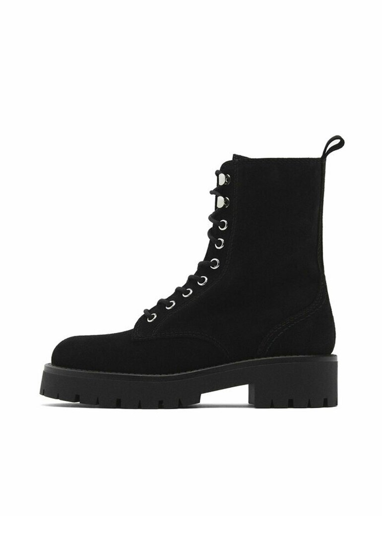 Bottines en daim noir avec un laçage à l'avant, des œillets argentés et une semelle en caoutchouc épaisse. Dotées d'une bride à l'arrière pour faciliter l'enfilage.