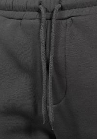 Pohodlné tepláky v antracitově šedé barvě se stahovací šňůrkou, mají texturovanou vazbu a boční kapsu. Měkký materiál zajišťuje volný střih.