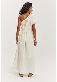 Maxi šaty na jedno rameno z jemnej smotanovej látky, so zberaním, zúženým pásom a splývavou sukňou s A-líniovou siluetou.