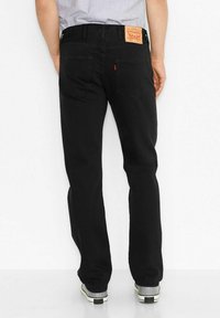 Zwarte denim jeans met een rechte pijp, achterzakken en een leren label op de tailleband. Heeft een gladde textuur en een klassiek ontwerp.