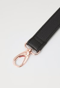 Black textured strap with a rose gold metal clip. The strap features a smooth finish and visible stitching details.