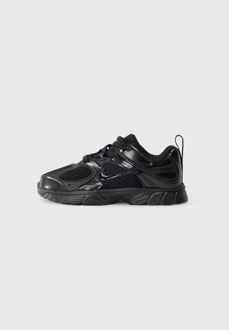 Sapatilha desportiva preta com parte superior em malha e sintético, possui bico redondo, sola de borracha grossa e o logótipo distinto da Nike na lateral.